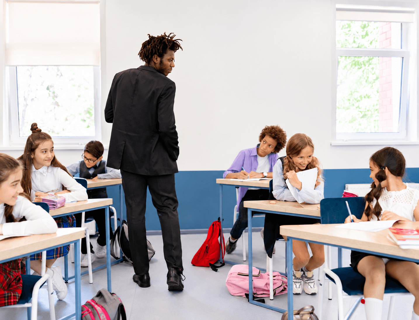 A math teacher working with students at their desks